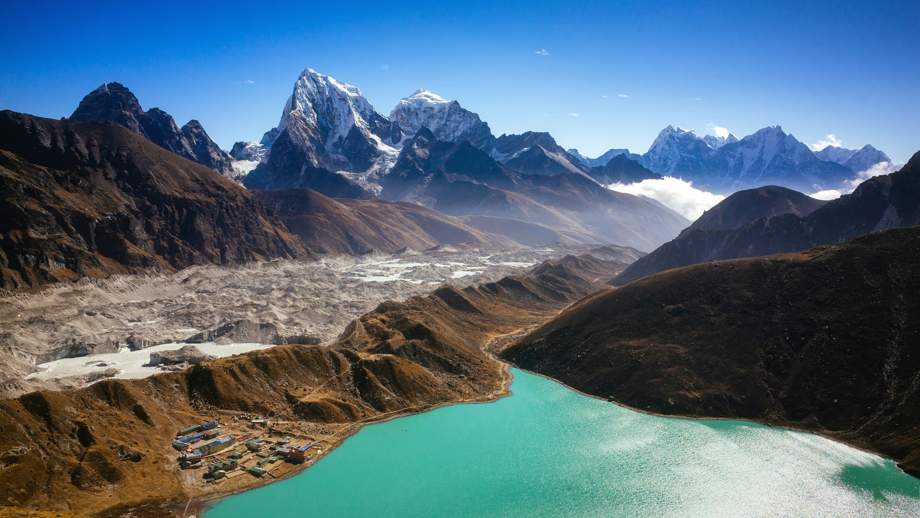 Snow-capped Himalayan peaks above a turquoise mountain lake